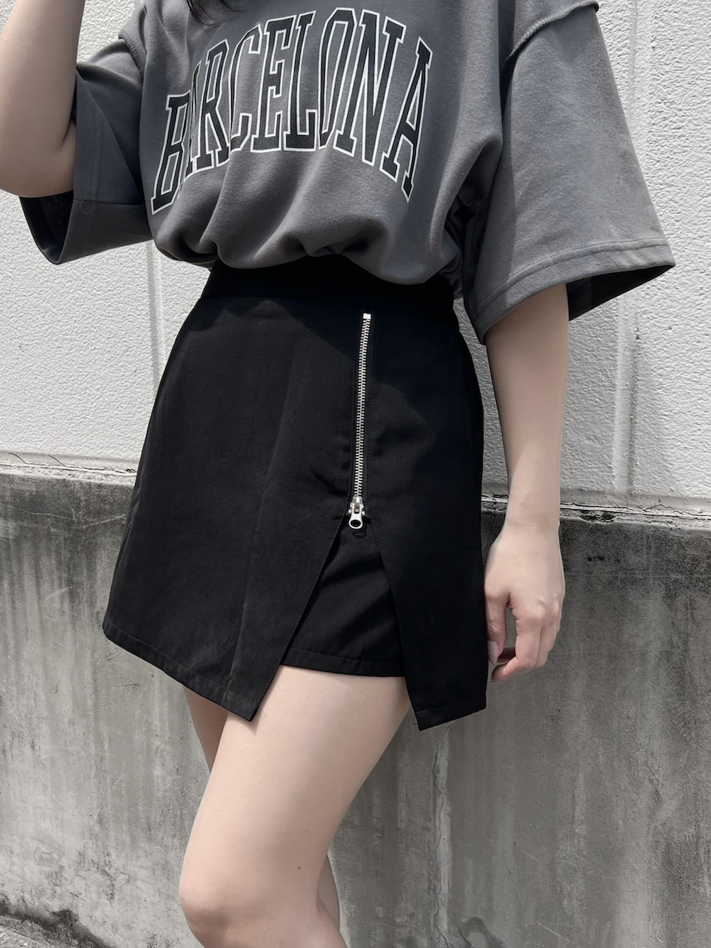 ブラック系のスニーカー、グレー系のTシャツ/カットソー、ブラック系のスカートを着用したレディースの夏コーディネートの3枚目の写真