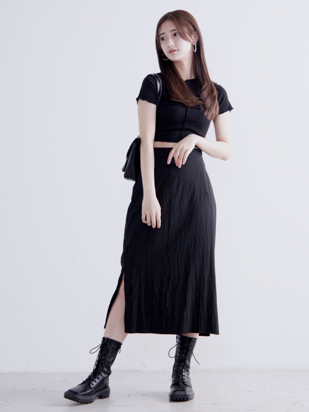 ブラック系のTシャツ/カットソー、ブラック系のスカート、ブラック系のショルダーバッグを着用したレディースの春コーディネートの3枚目の写真