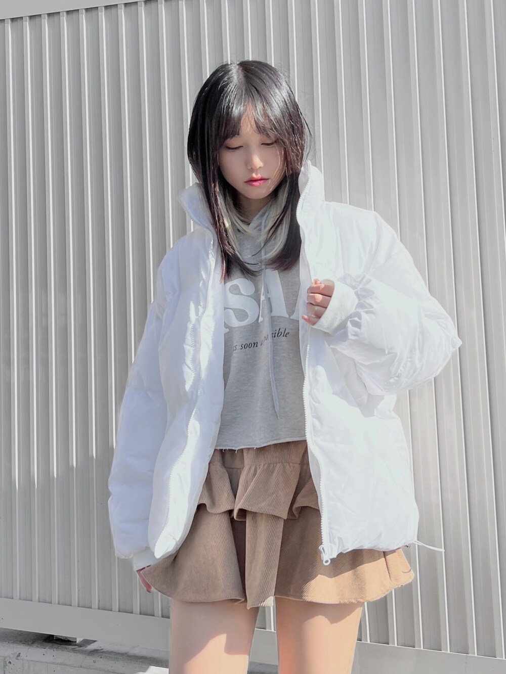 ホワイト系のダウンジャケット/コート、ホワイト系のブーツ、グレー系のパーカーを着用したレディースの冬コーディネートの2枚目の写真