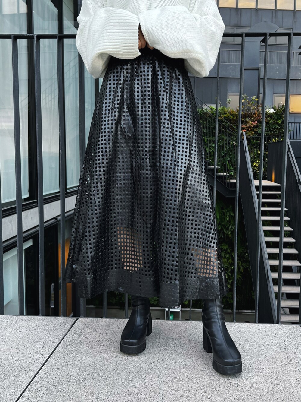 ホワイト系のニット/セーター、ブラック系のTシャツ/カットソー、ブラック系のブーツを着用したレディースの冬コーディネートの4枚目の写真