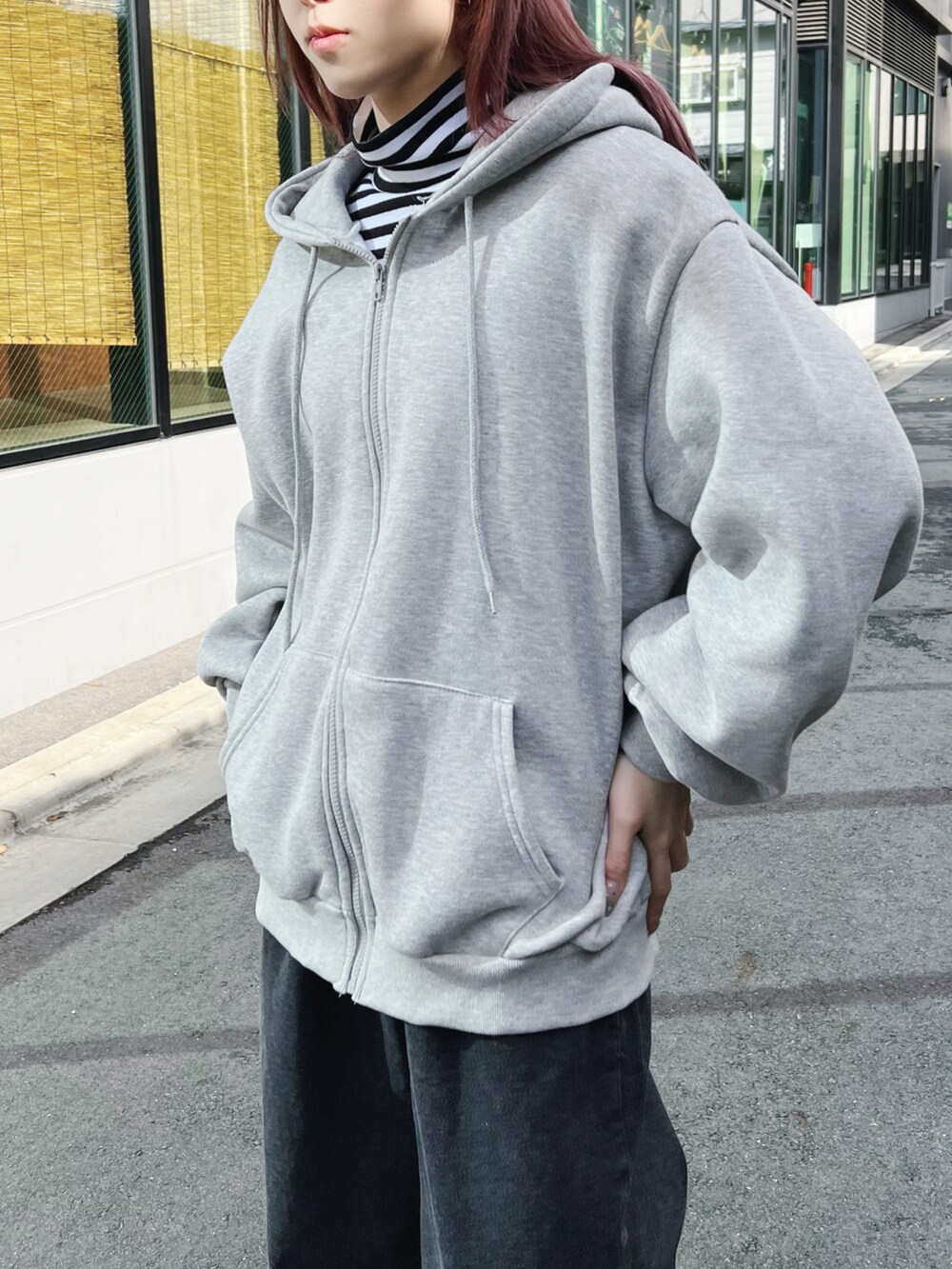 ブラック系のデニムパンツ、ホワイト系のTシャツ/カットソー、グレー系のパーカーを着用したレディースの冬コーディネートの2枚目の写真