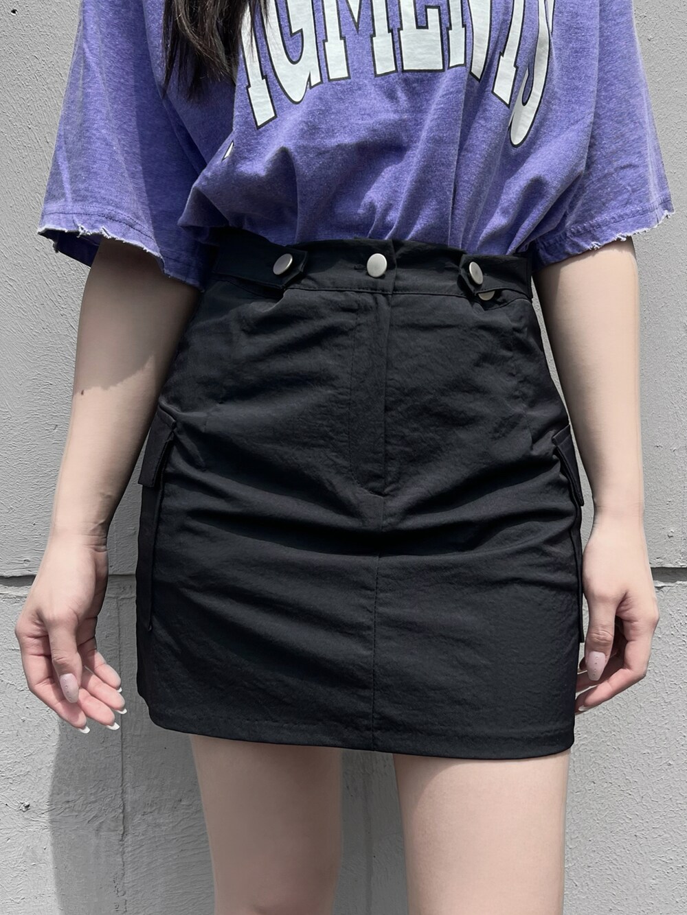 パープル系のTシャツ/カットソー、ブラック系のスカート、シルバー系のネックレスを着用したレディースの春コーディネートの4枚目の写真