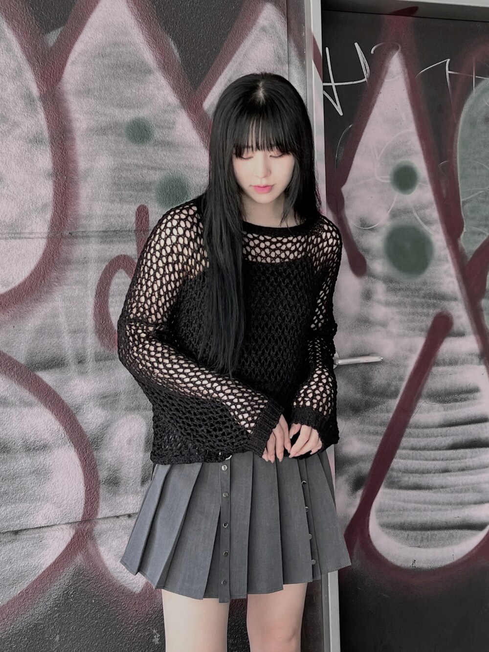 ブラック系のブーツ、ブラック系のニット/セーター、グレー系のスカートを着用したレディースの夏コーディネートの3枚目の写真