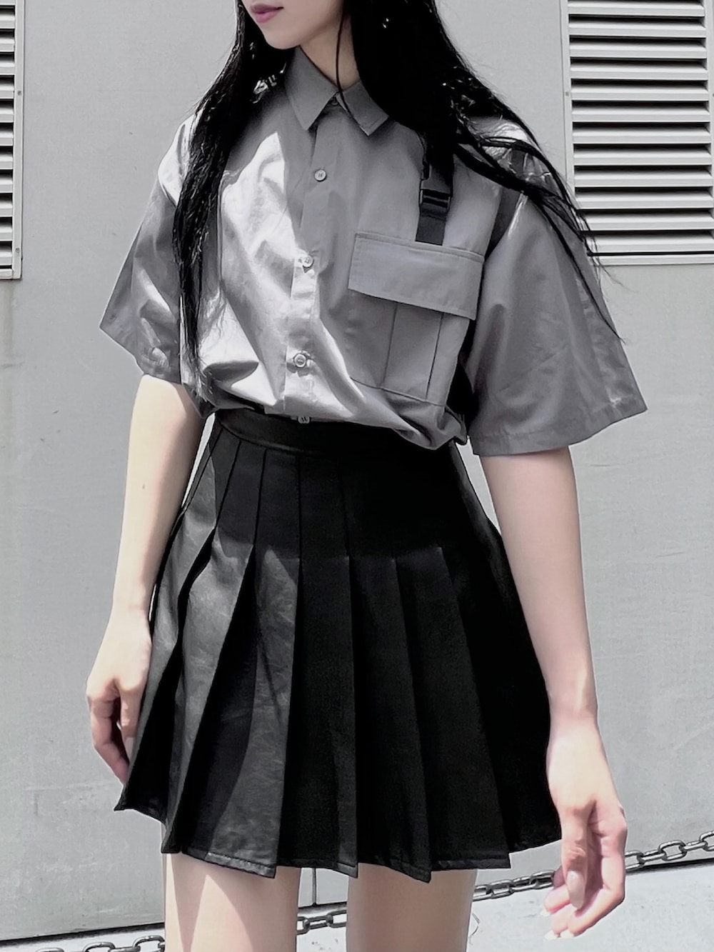 ブラック系のスカート、ブラック系のブーツ、グレー系のシャツ/ブラウスを着用したレディースの夏コーディネートの2枚目の写真