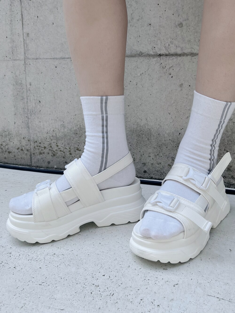 ホワイト系のサンダル、ホワイト系のスカート、ホワイト系のTシャツ/カットソーを着用したレディースの夏コーディネートの4枚目の写真