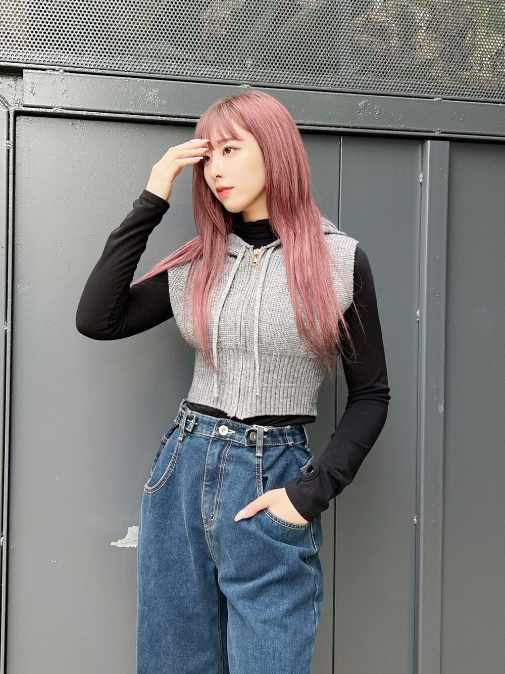 ブルー系のデニムパンツ、ブラック系のスニーカー、グレー系のベストを着用したレディースの冬コーディネートの3枚目の写真