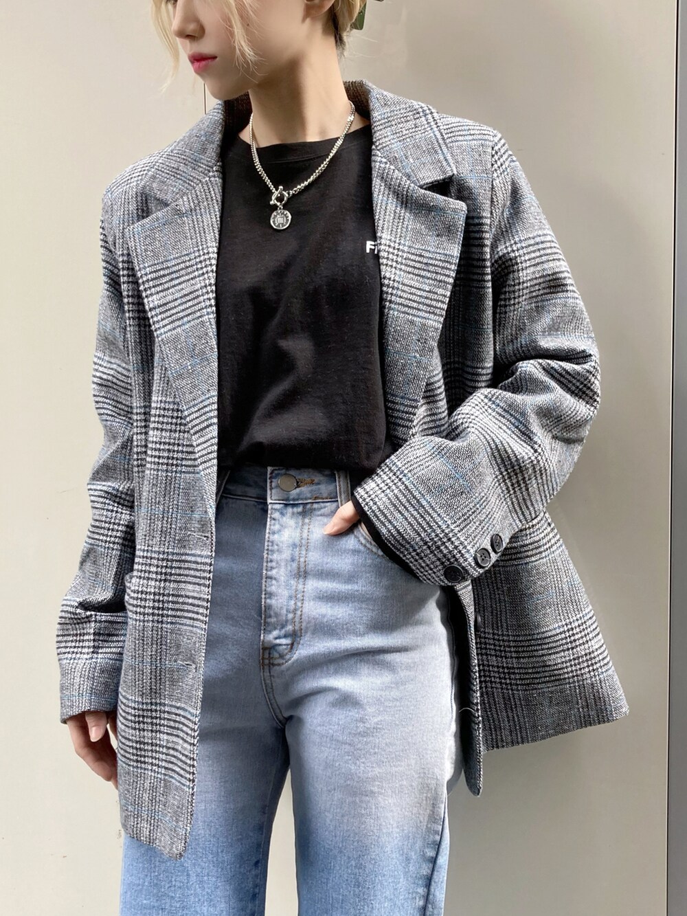 ブルー系のデニムパンツ、グレー系のテーラードジャケット、ブラック系のTシャツ/カットソーを着用したレディースの秋コーディネートの2枚目の写真