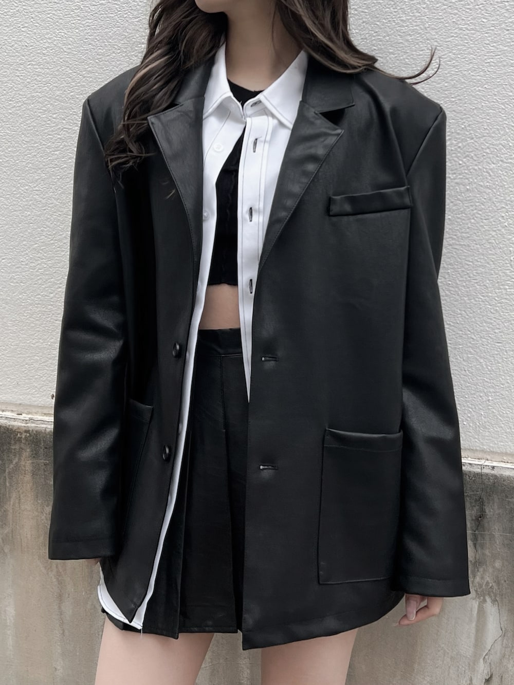 ホワイト系のシャツ/ブラウス、ブラック系のスカート、ブラック系のブーツを着用したレディースの春コーディネートの3枚目の写真