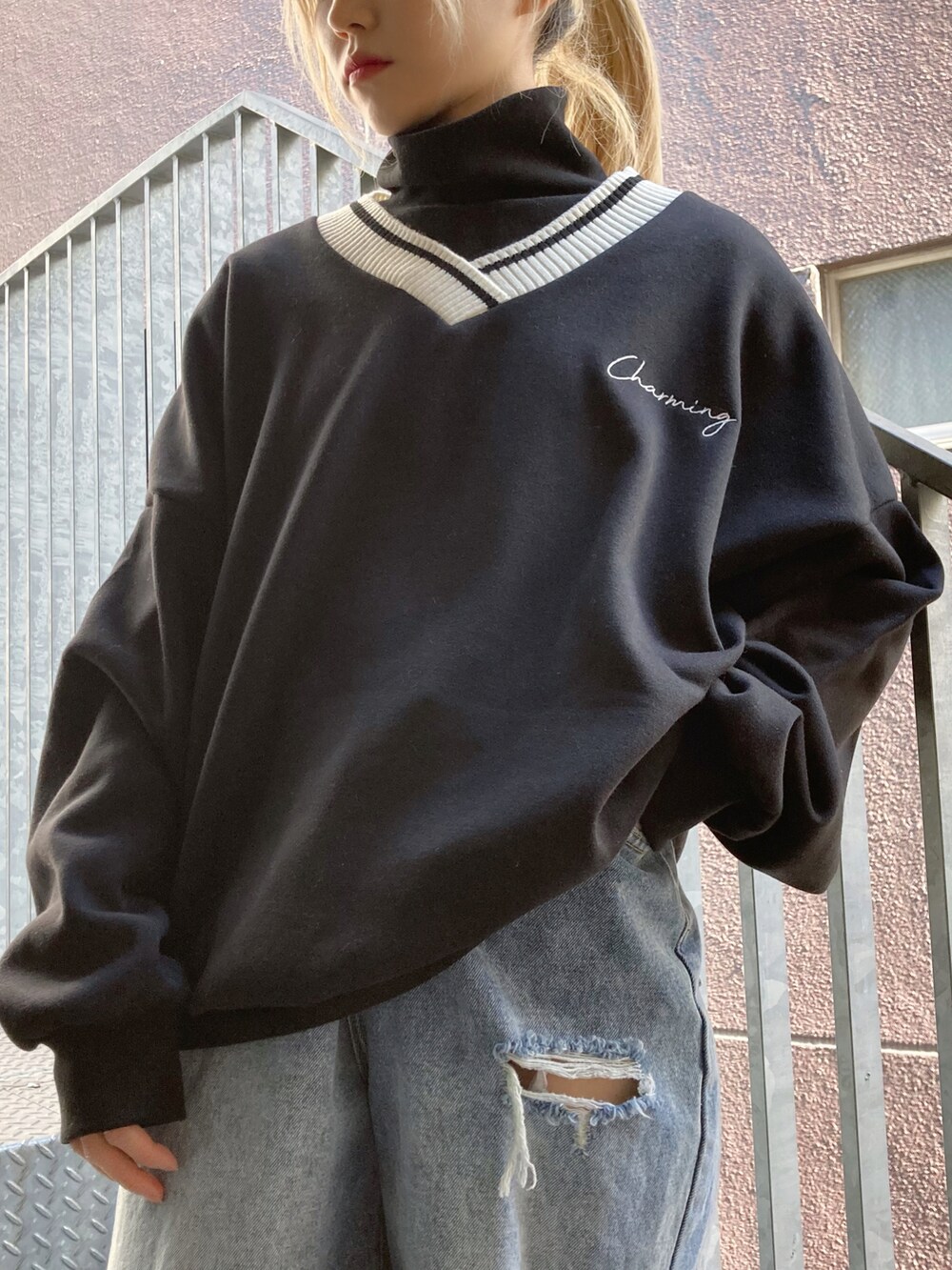 ブラック系のスウェット、ブラック系のTシャツ/カットソー、ブルー系のデニムパンツを着用したレディースの冬コーディネートの2枚目の写真