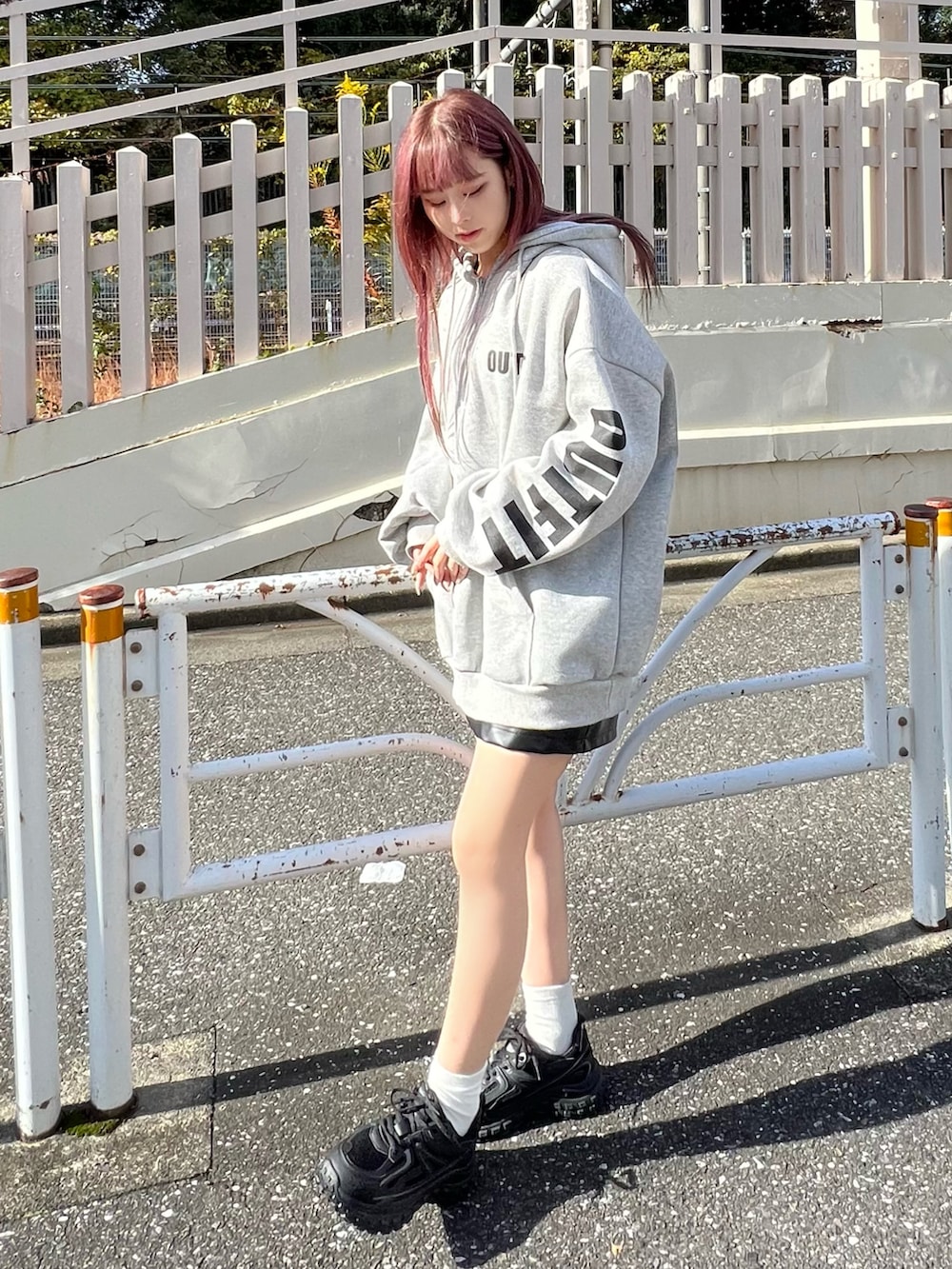 ブラック系のスニーカー、ブラック系のスカート、グレー系のパーカーを着用したレディースの冬コーディネートの2枚目の写真