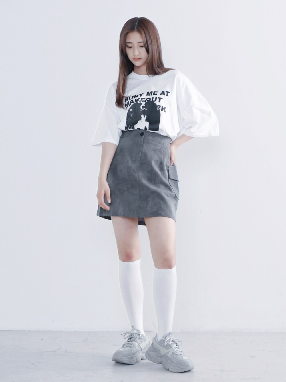 ホワイト系のTシャツ/カットソー、ブラック系のスカート、グレー系のスニーカーを着用したレディースの夏コーディネートの2枚目の写真