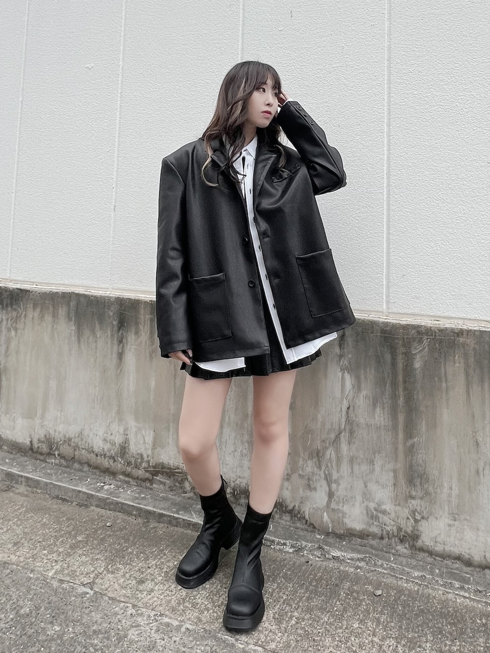 ホワイト系のシャツ/ブラウス、ブラック系のスカート、ブラック系のブーツを着用したレディースの春コーディネートの2枚目の写真