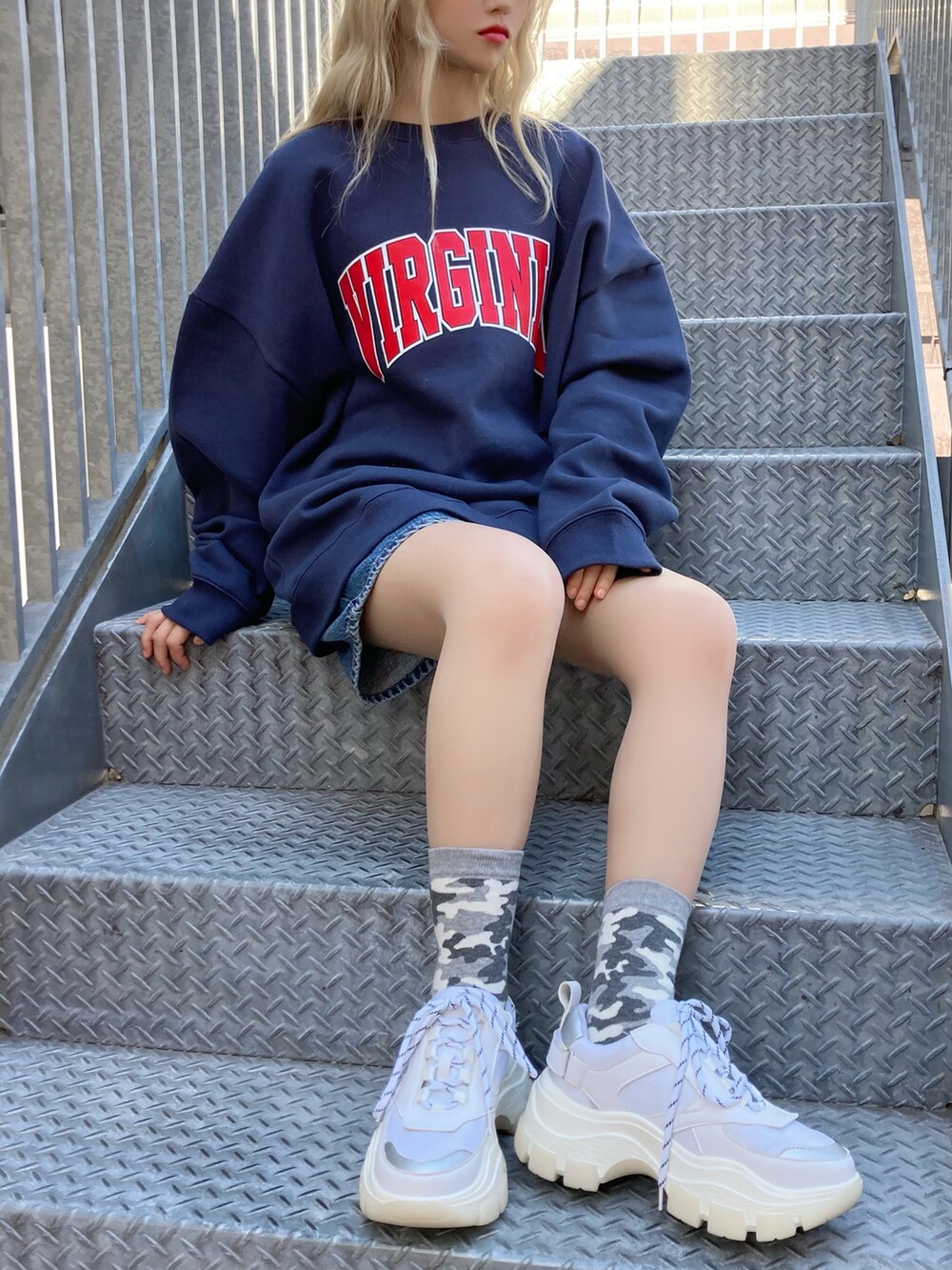 グリーン系のMA-1、ブルー系のデニムパンツ、ホワイト系のスニーカーを着用したレディースの冬コーディネートの2枚目の写真