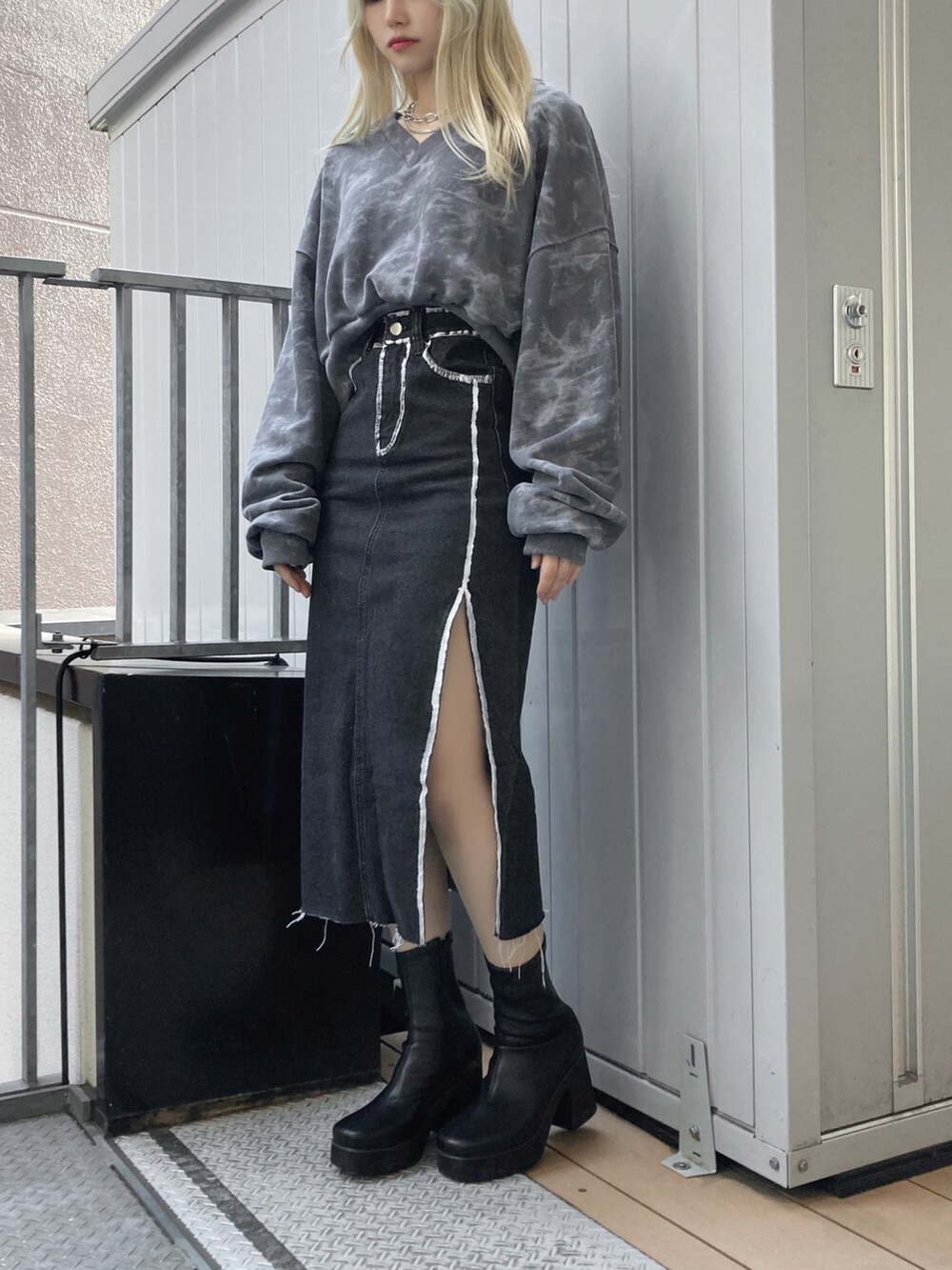 ブラック系のブーツ、ブラック系のスウェット、ブラック系のスカートを着用したレディースの冬コーディネートの2枚目の写真