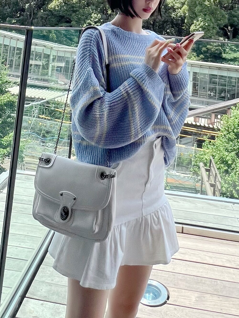 ブルー系のニット/セーター、ホワイト系のスカート、ホワイト系のサンダルを着用したレディースの夏コーディネートの2枚目の写真