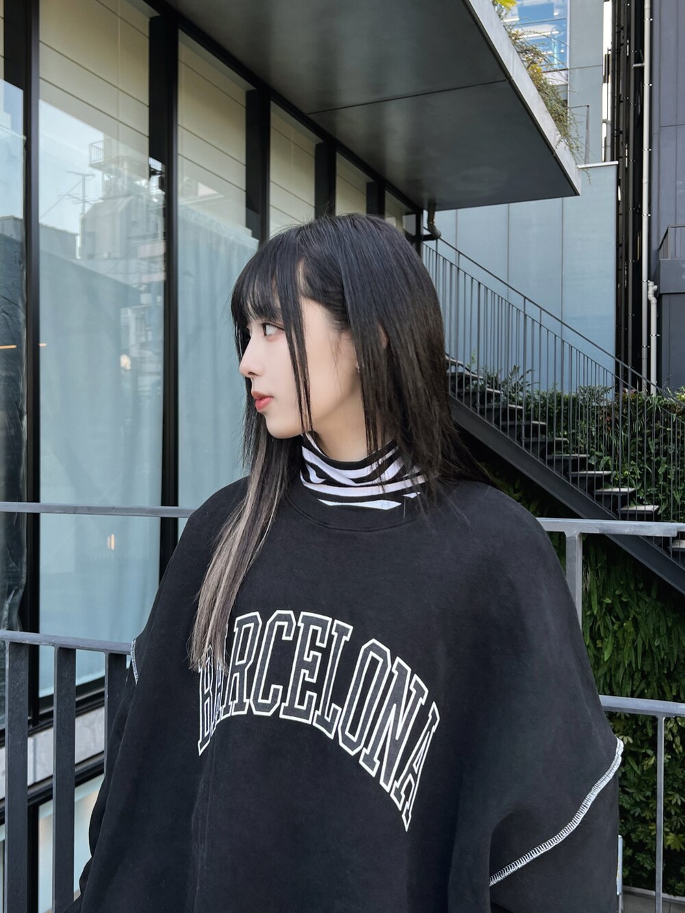 ブラック系のスウェット、ブラック系のブーツ、ホワイト系のTシャツ/カットソーを着用したレディースの冬コーディネートの4枚目の写真