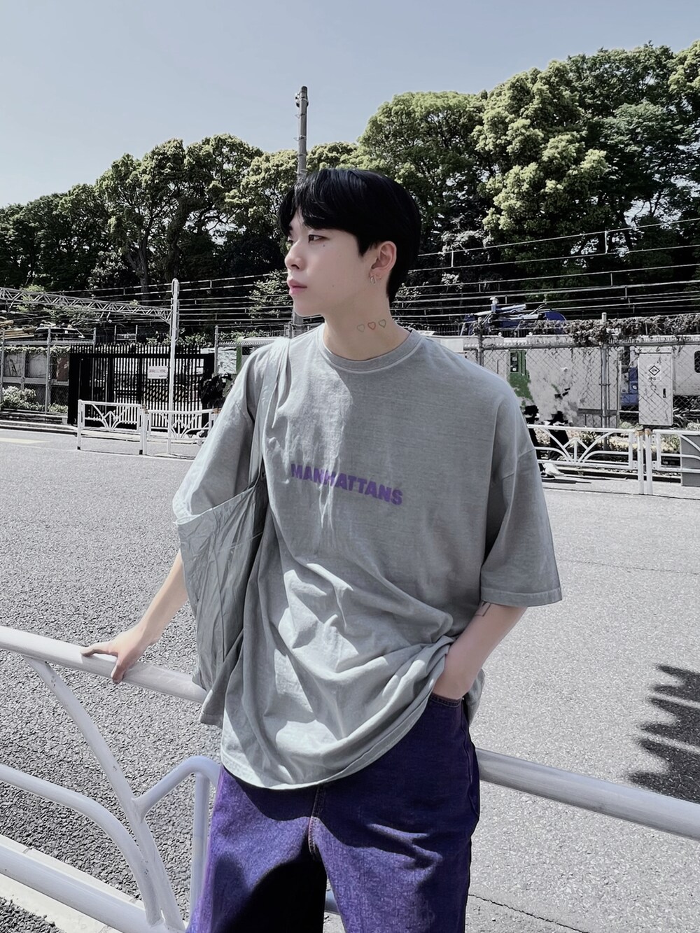 パープル系のデニムパンツ、ホワイト系のスニーカー、シルバー系のショルダーバッグを着用したレディースの春コーディネートの2枚目の写真