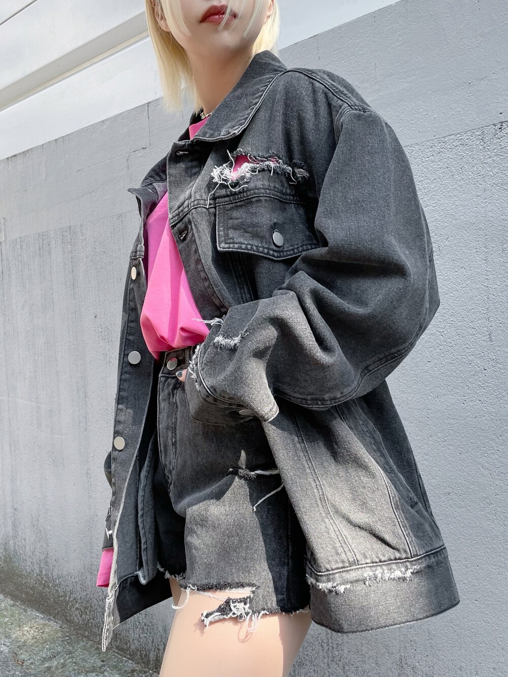 ブラック系のデニムジャケット、ブラック系のデニムパンツ、ピンク系のTシャツ/カットソーを着用したレディースの春コーディネートの2枚目の写真