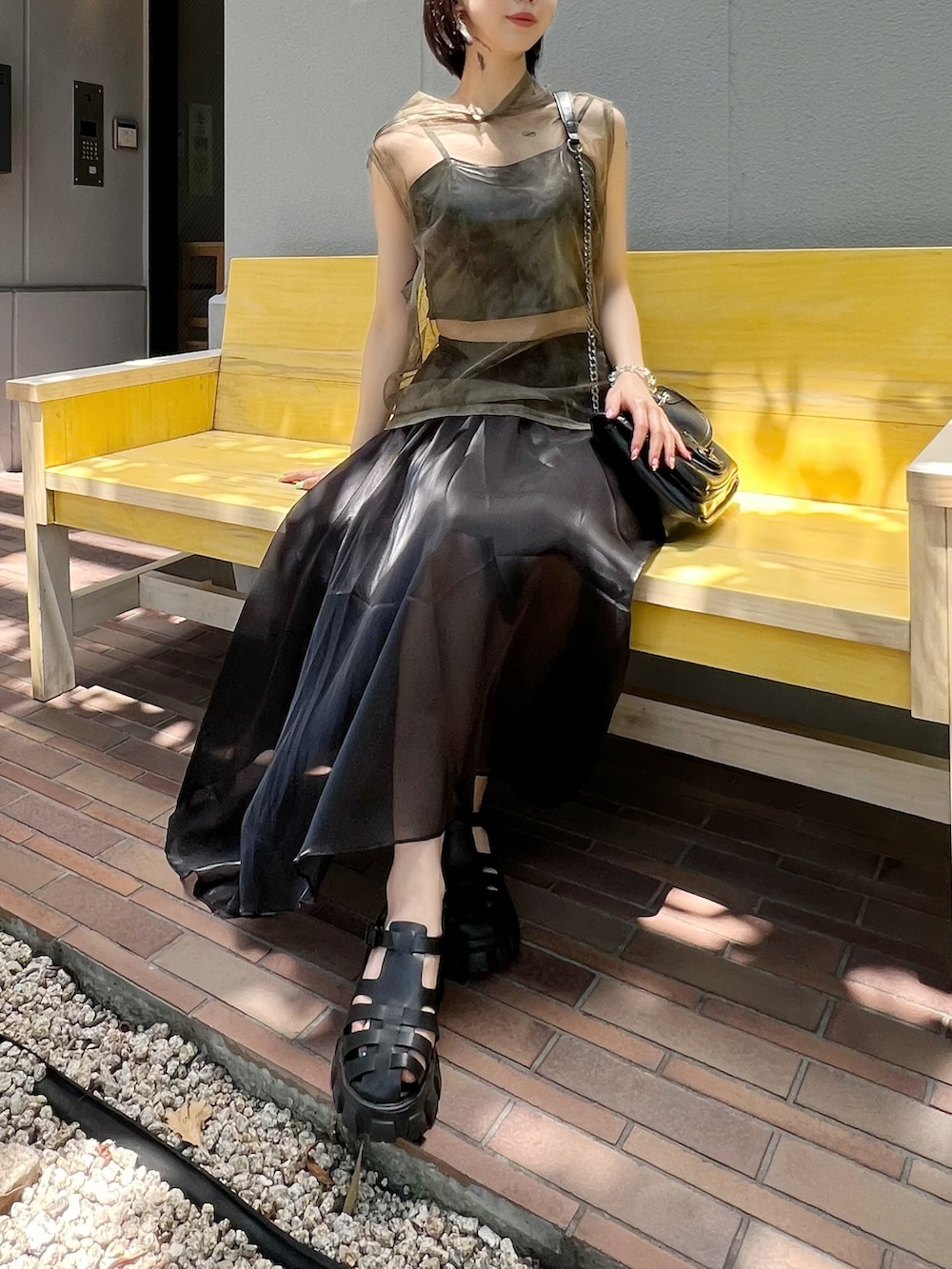 ブラック系のサンダル、ブラック系のスカート、グリーン系のTシャツ/カットソーを着用したレディースの夏コーディネートの3枚目の写真