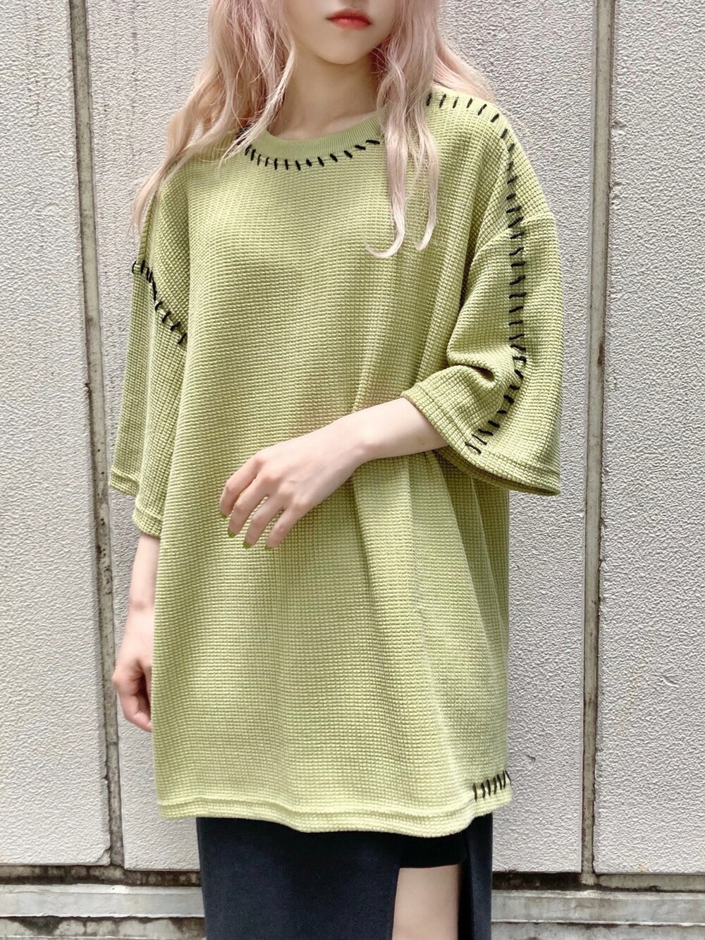 グリーン系のニット/セーター、ブラック系のスカート、ブラック系のトートバッグを着用したレディースの夏コーディネートの3枚目の写真