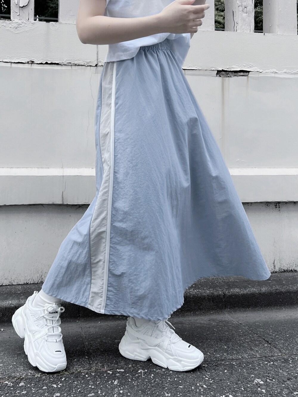 ホワイト系のTシャツ/カットソー、ブルー系のスカート、ホワイト系のスニーカーを着用したレディースの春コーディネートの2枚目の写真