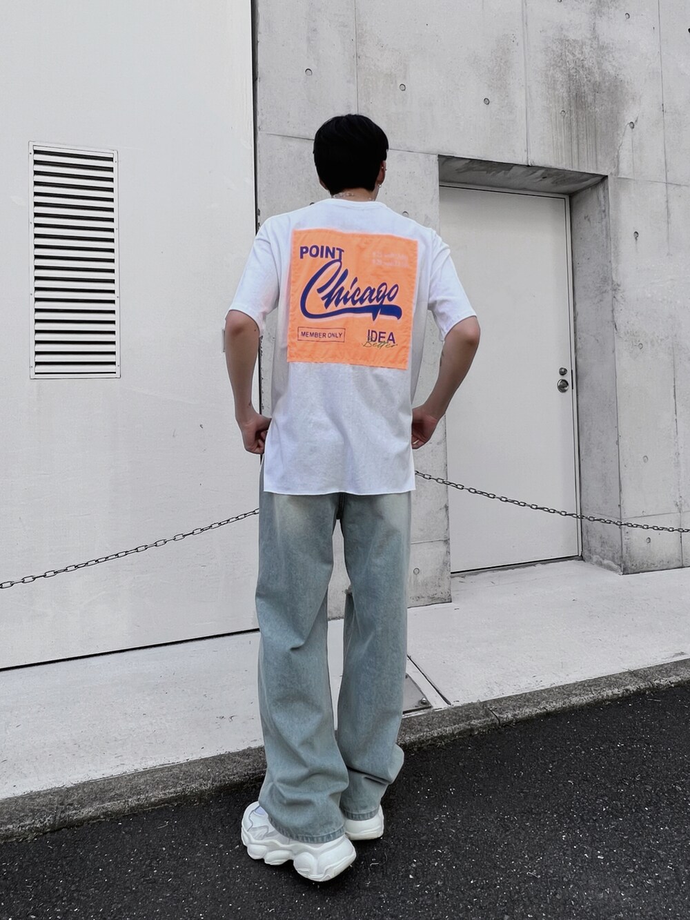 ブルー系のデニムパンツ、グレー系のバックパック/リュック、ホワイト系のTシャツ/カットソーを着用したメンズの春コーディネートの4枚目の写真