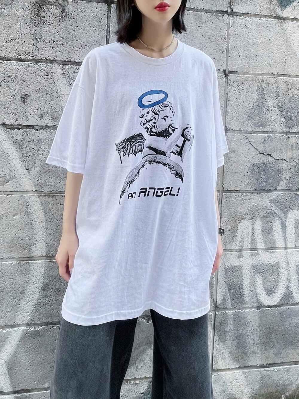 ブラック系のデニムパンツ、ホワイト系のTシャツ/カットソー、ブラック系のスニーカーを着用したレディースの夏コーディネートの2枚目の写真