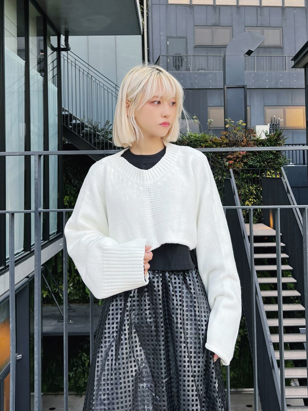 ホワイト系のニット/セーター、ブラック系のTシャツ/カットソー、ブラック系のブーツを着用したレディースの冬コーディネートの3枚目の写真