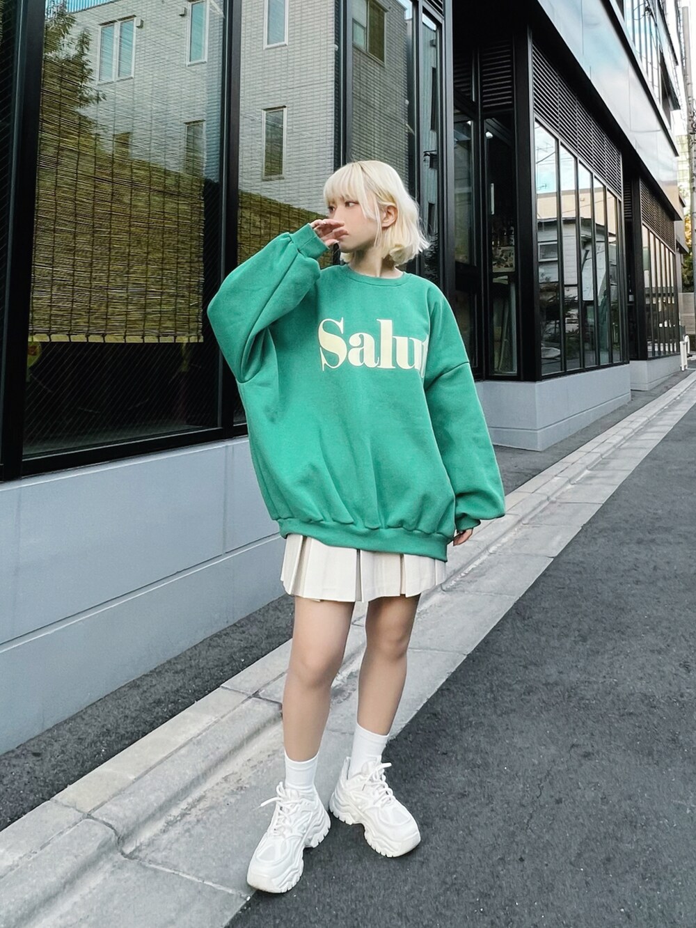 ホワイト系のダウンベスト、ホワイト系のスカート、ホワイト系のスニーカーを着用したレディースの冬コーディネートの4枚目の写真