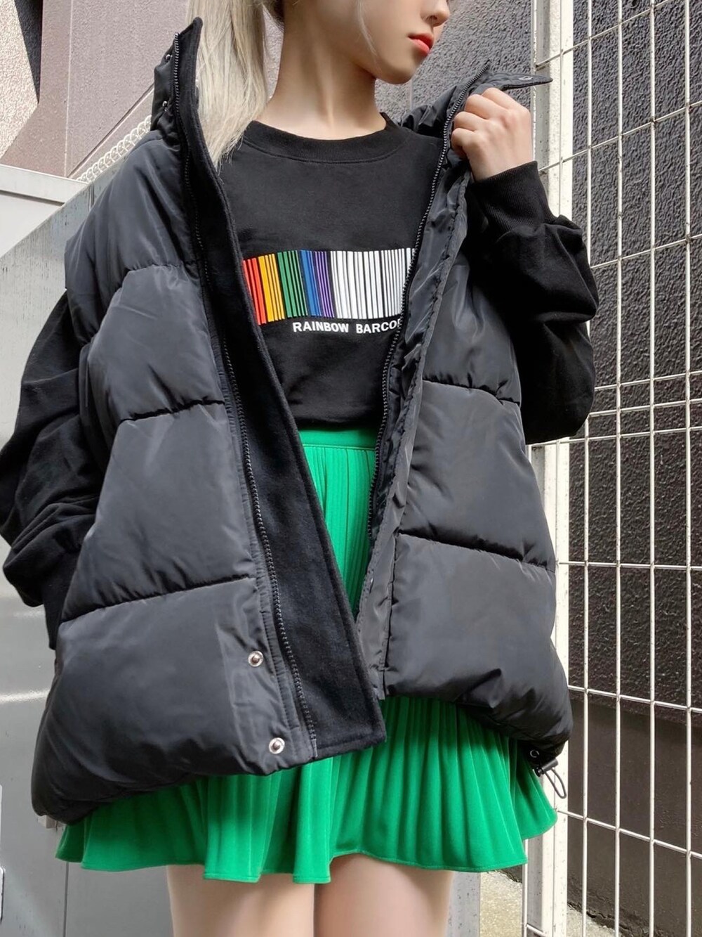 ブラック系のベスト、ブラック系のスウェット、グリーン系のスカートを着用したレディースの春コーディネートの2枚目の写真