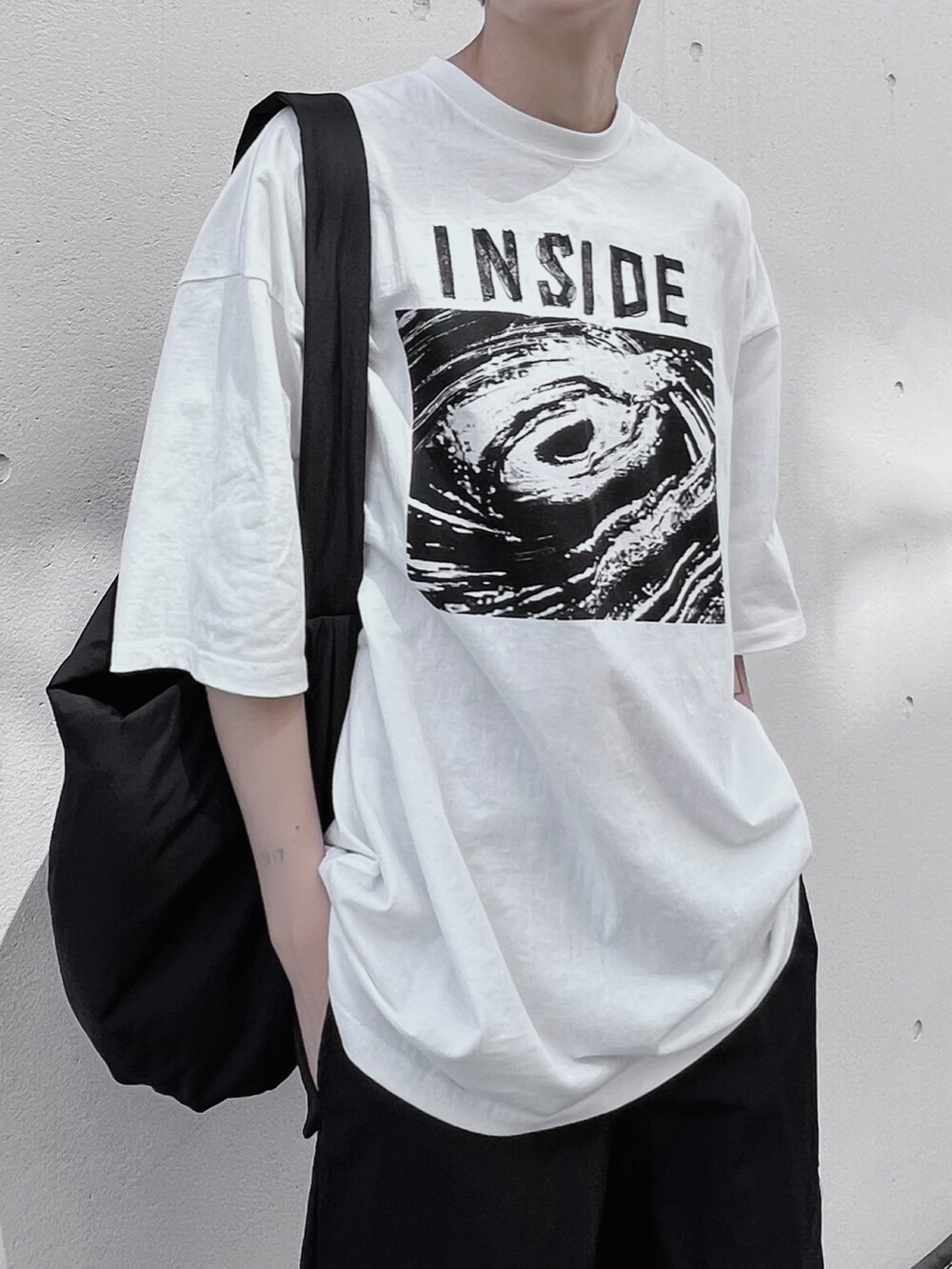 ブラック系のショルダーバッグ、ホワイト系のTシャツ/カットソー、ホワイト系のスニーカーを着用したメンズの春コーディネートの2枚目の写真