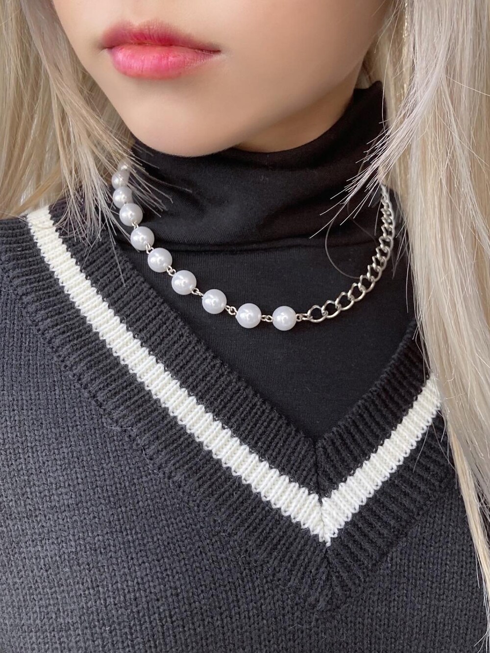 ブラック系のニット/セーター、ブラック系のトートバッグ、ブラック系のTシャツ/カットソーを着用したレディースの春コーディネートの3枚目の写真