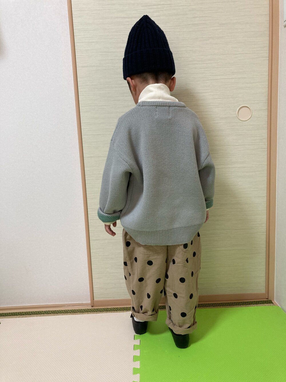 グレー系のニット/セーター、ブラック系のローファー、イエロー系のTシャツ/カットソーを着用したキッズの冬コーディネートの2枚目の写真