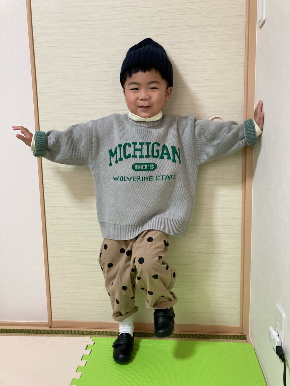 グレー系のニット/セーター、ブラック系のローファー、イエロー系のTシャツ/カットソーを着用したキッズの冬コーディネートの3枚目の写真