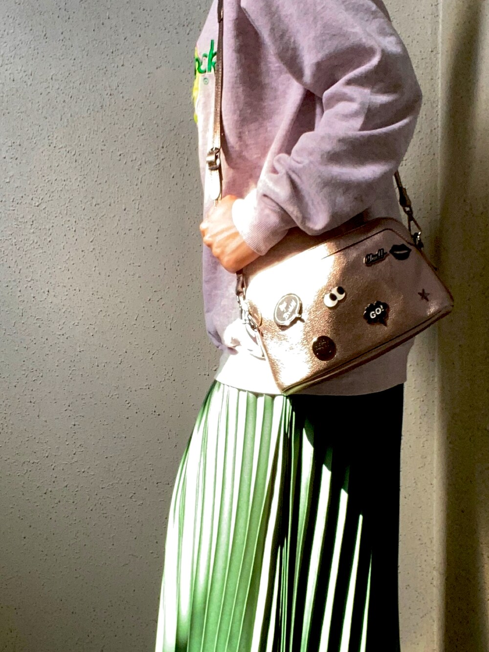 ピンク系のスウェット、グリーン系のスカート、ホワイト系のスニーカーを着用したレディースの春コーディネートの3枚目の写真