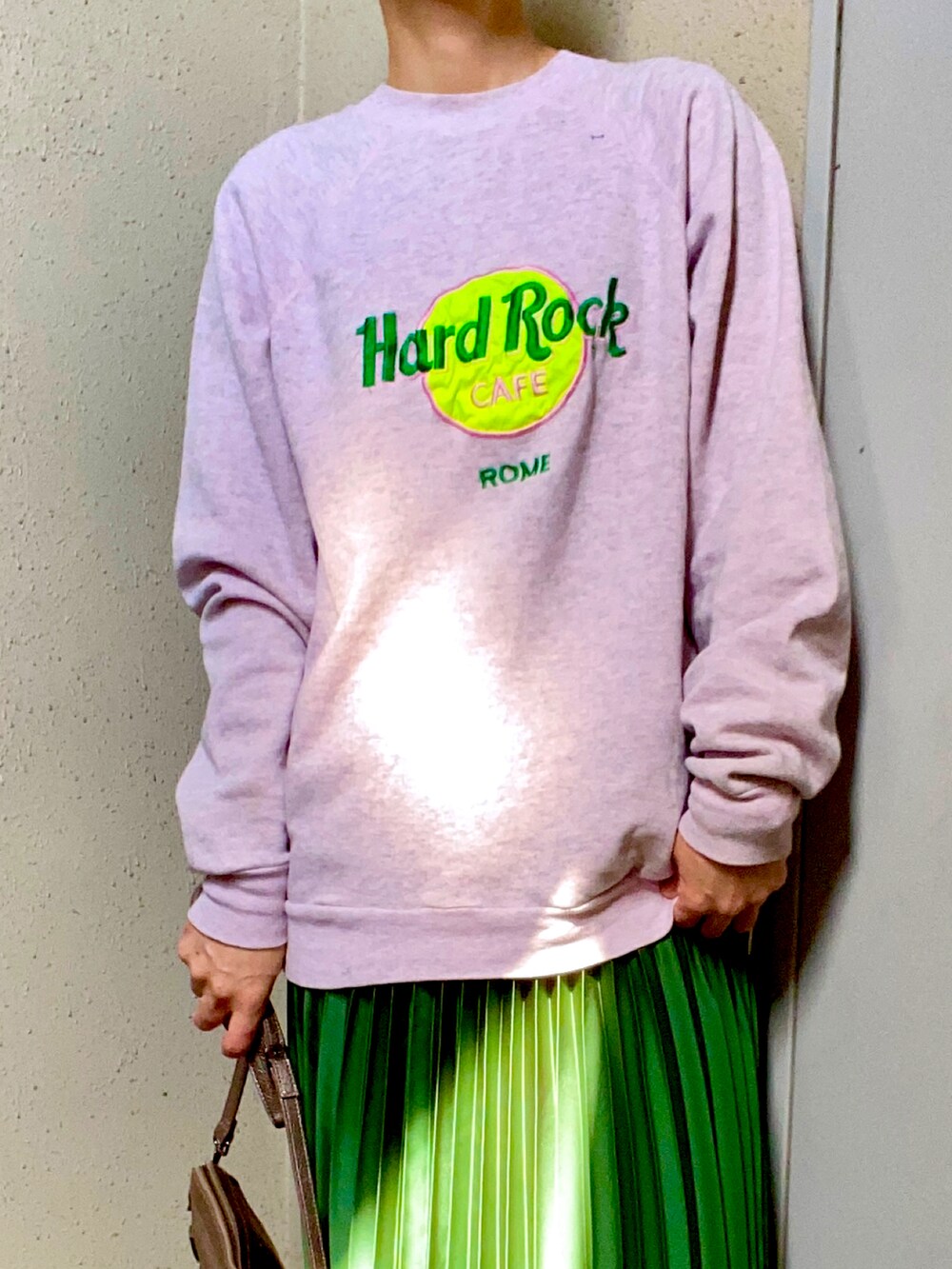 ピンク系のスウェット、グリーン系のスカート、ホワイト系のスニーカーを着用したレディースの春コーディネートの2枚目の写真