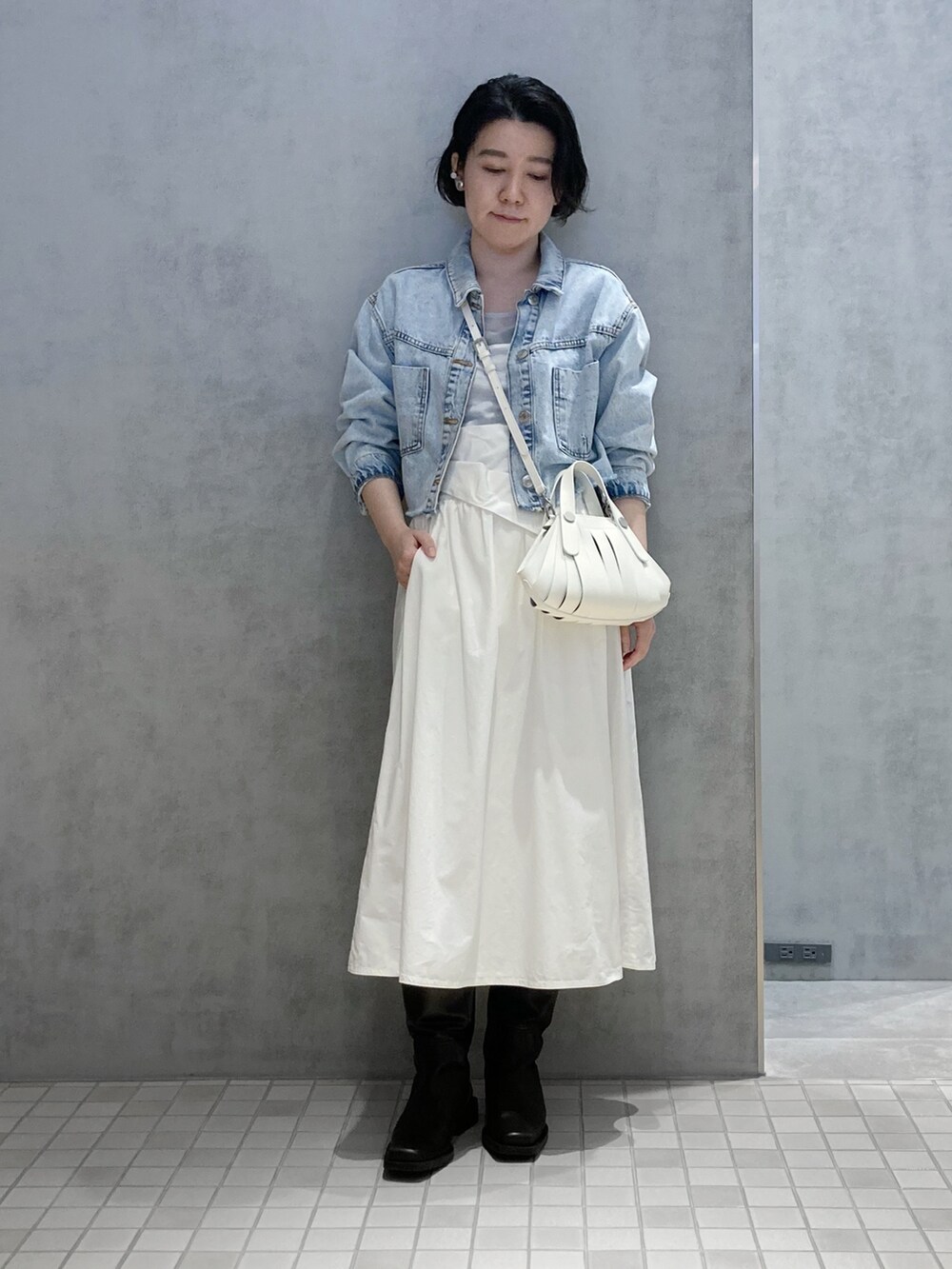 ホワイト系のハンドバッグ、シルバー系のイヤリング、シルバー系のイヤリングを着用したレディースの春コーディネートの4枚目の写真