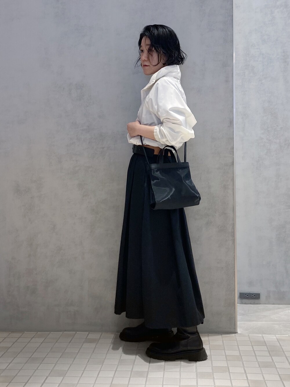 ブラック系のショルダーバッグ、シルバー系のイヤリング、ゴールド系のイヤリングを着用したレディースの春コーディネートの2枚目の写真