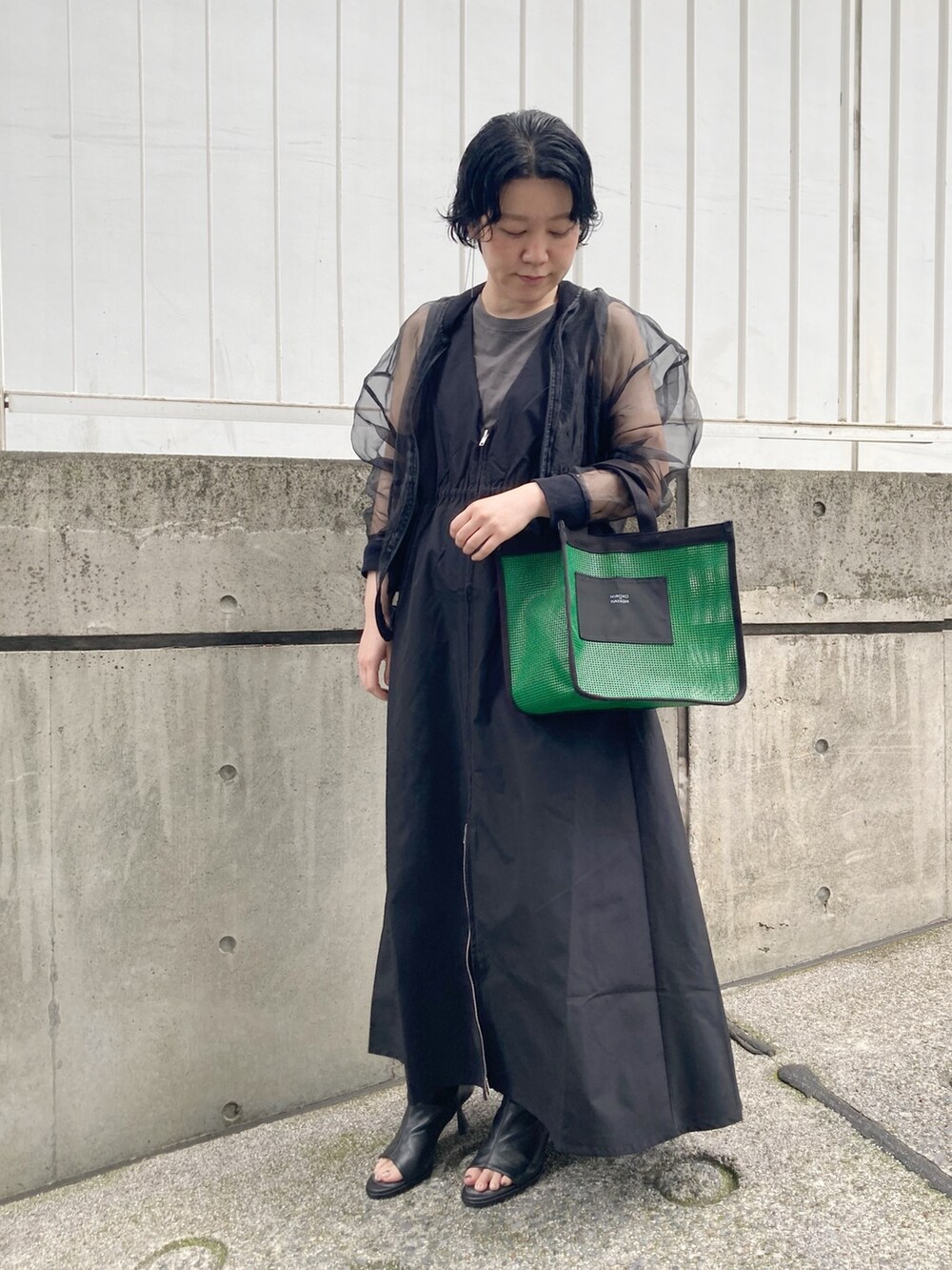 グリーン系のハンドバッグを着用したレディースの夏コーディネートの2枚目の写真
