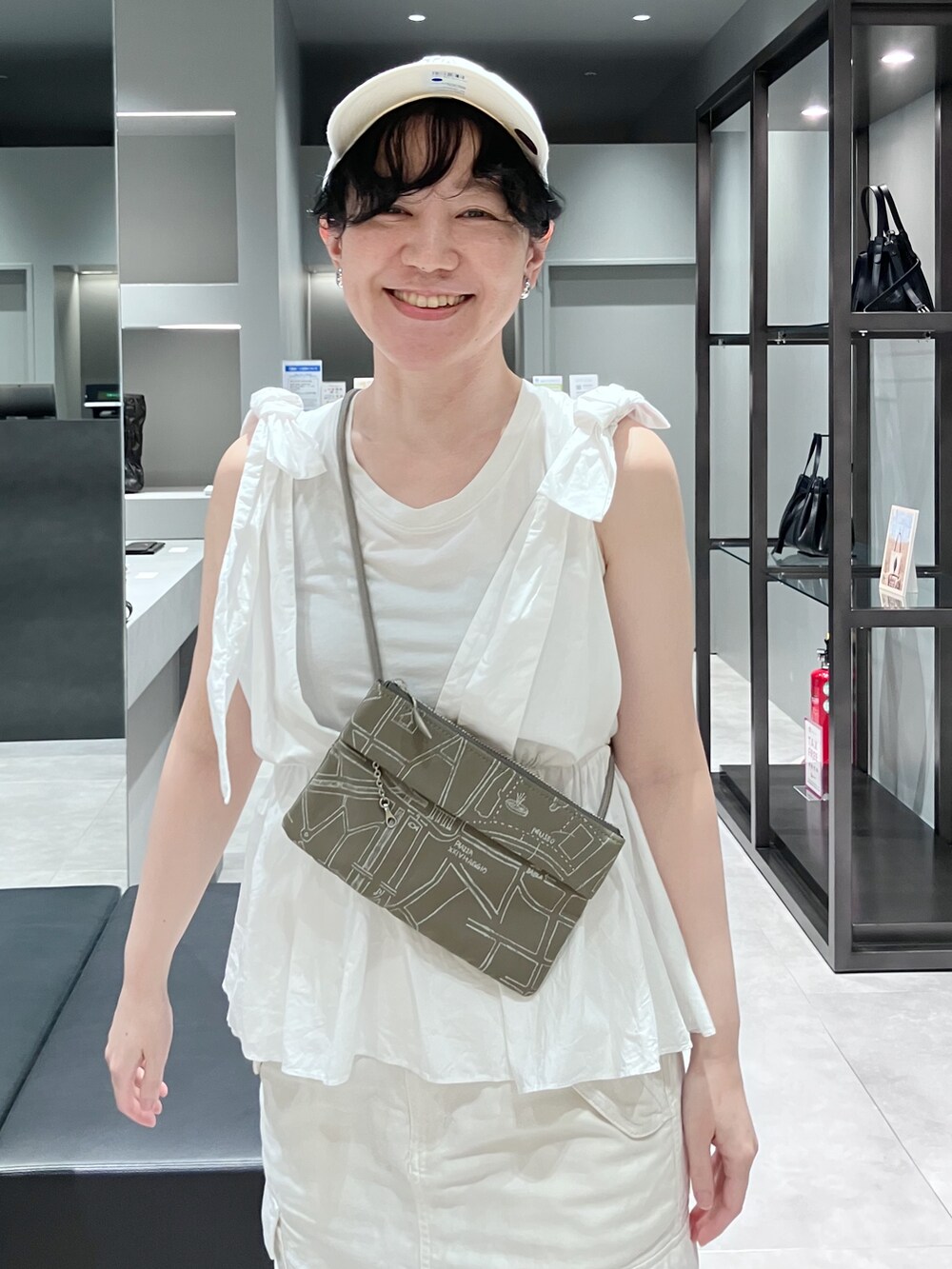 ブラック系のショルダーバッグ、ベージュ系のショルダーバッグを着用したレディースの夏コーディネートの4枚目の写真