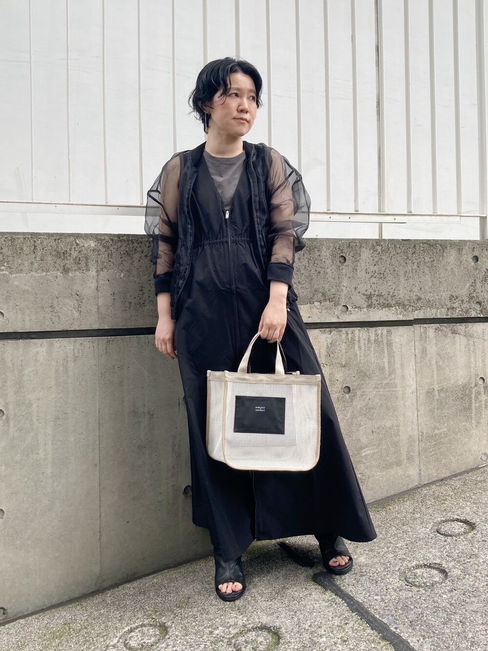 ホワイト系のハンドバッグを着用したレディースの夏コーディネートの3枚目の写真