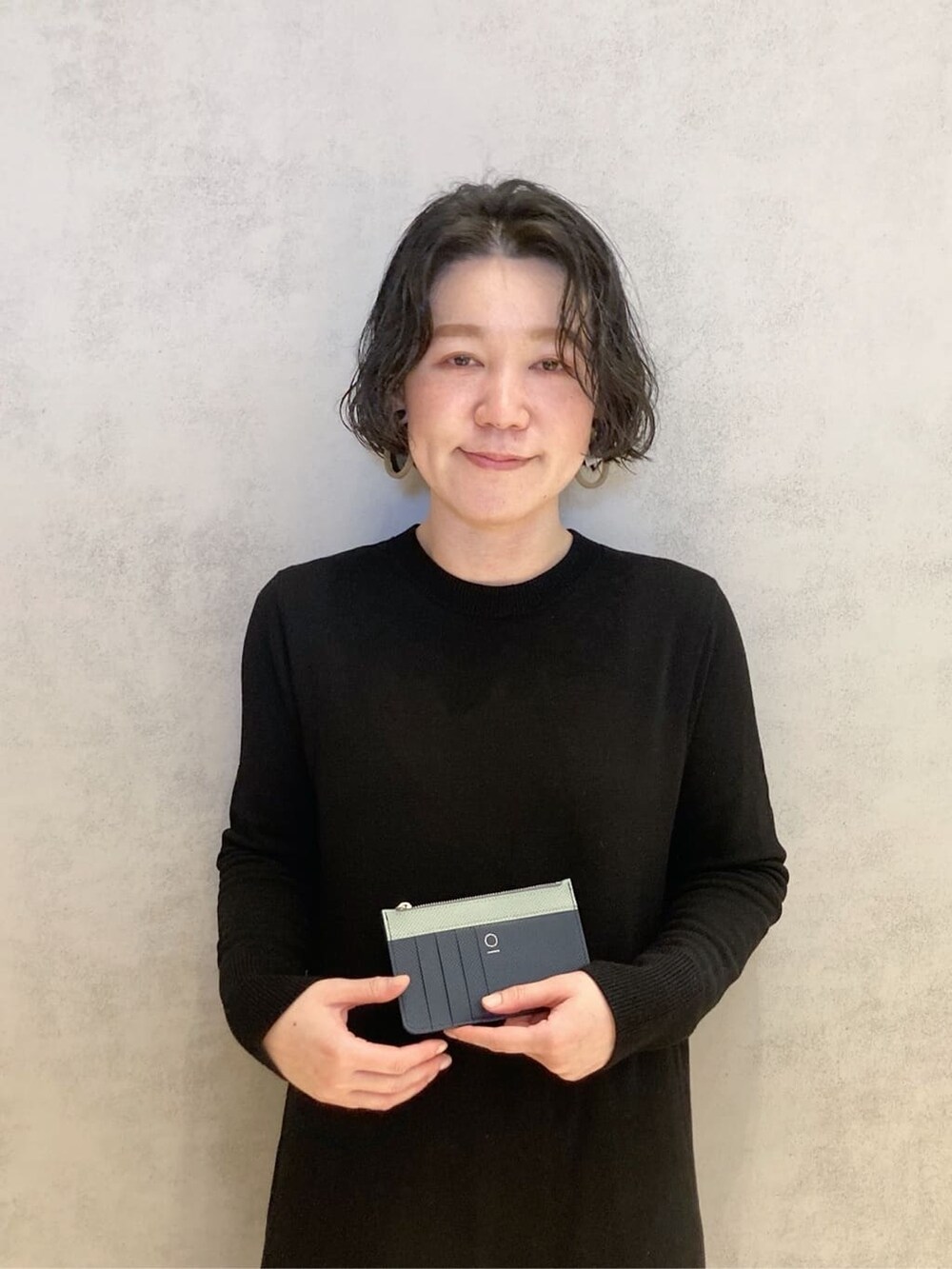 オレンジ系の財布、ブラック系の財布、ブルー系の財布を着用したレディースの冬コーディネートの3枚目の写真