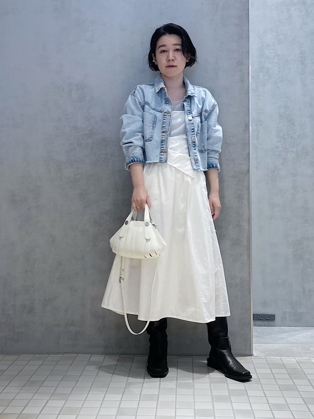 ホワイト系のハンドバッグ、シルバー系のイヤリング、シルバー系のイヤリングを着用したレディースの春コーディネートの3枚目の写真