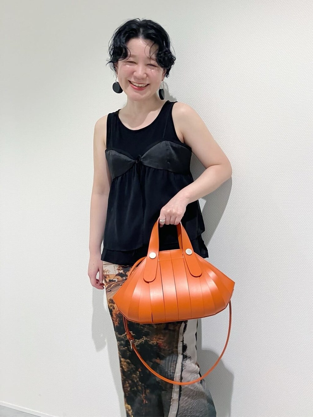オレンジ系のハンドバッグを着用したレディースの夏コーディネートの8枚目の写真