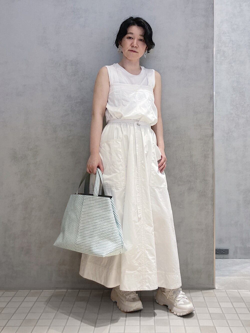 グリーン系のトートバッグを着用したレディースの夏コーディネートの2枚目の写真