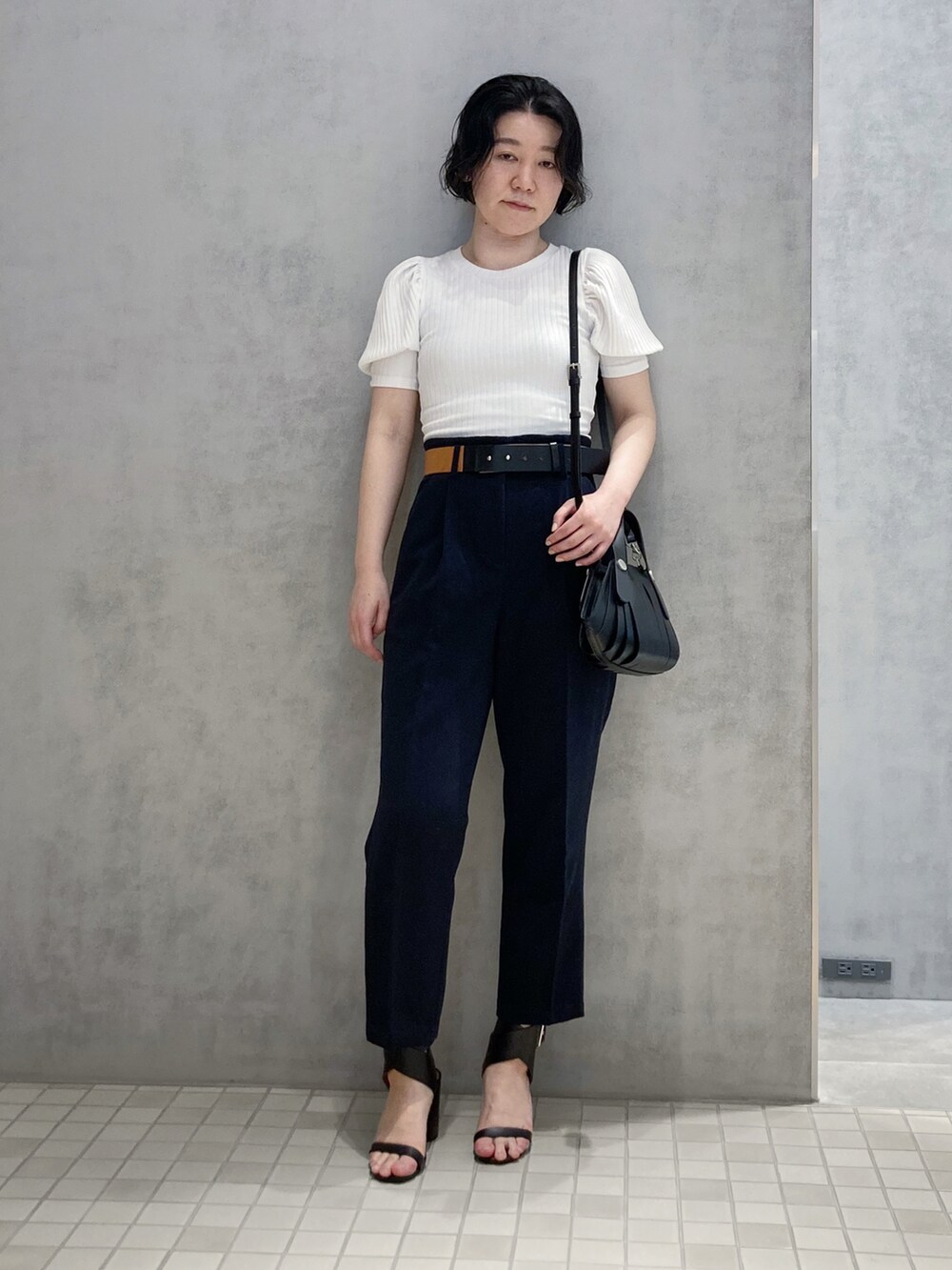 ブラック系のハンドバッグを着用したレディースの春コーディネートの2枚目の写真