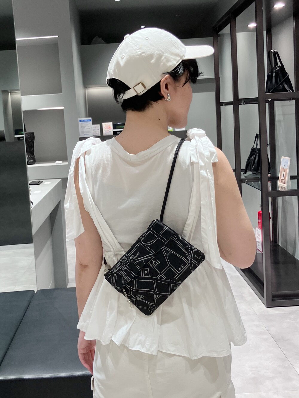 ブラック系のショルダーバッグ、ベージュ系のショルダーバッグを着用したレディースの夏コーディネートの2枚目の写真