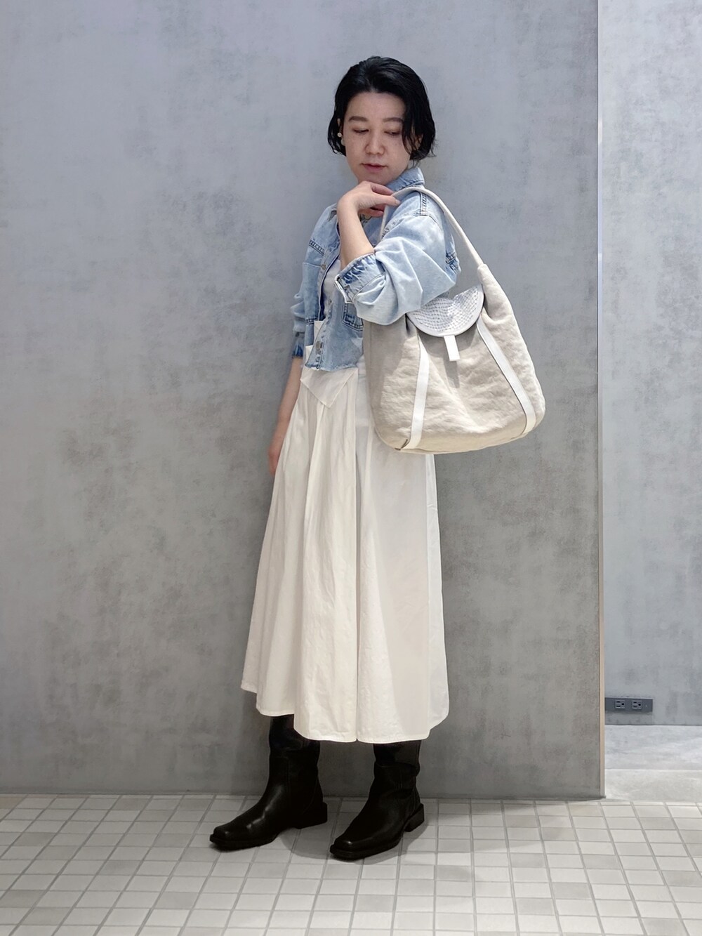 ホワイト系のショルダーバッグ、シルバー系のイヤリング、シルバー系のイヤリングを着用したレディースの春コーディネートの2枚目の写真