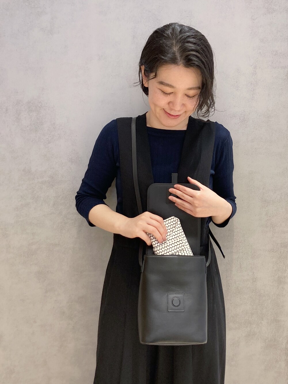 ブラック系のショルダーバッグ、ホワイト系の財布を着用したレディースの春コーディネートの5枚目の写真