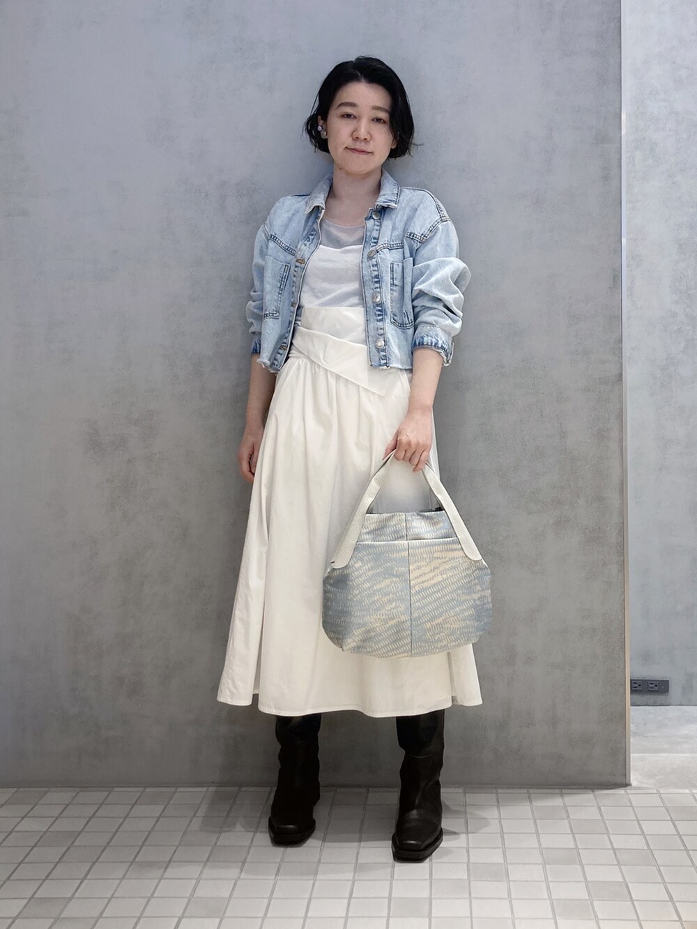 ベージュ系のハンドバッグ、シルバー系のイヤリング、シルバー系のイヤリングを着用したレディースの春コーディネートの2枚目の写真